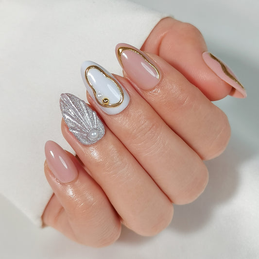Luxe soft gel press-on nagels met gouden lijnen, pareldetails, schelpdesign en nude basis in almond vorm
